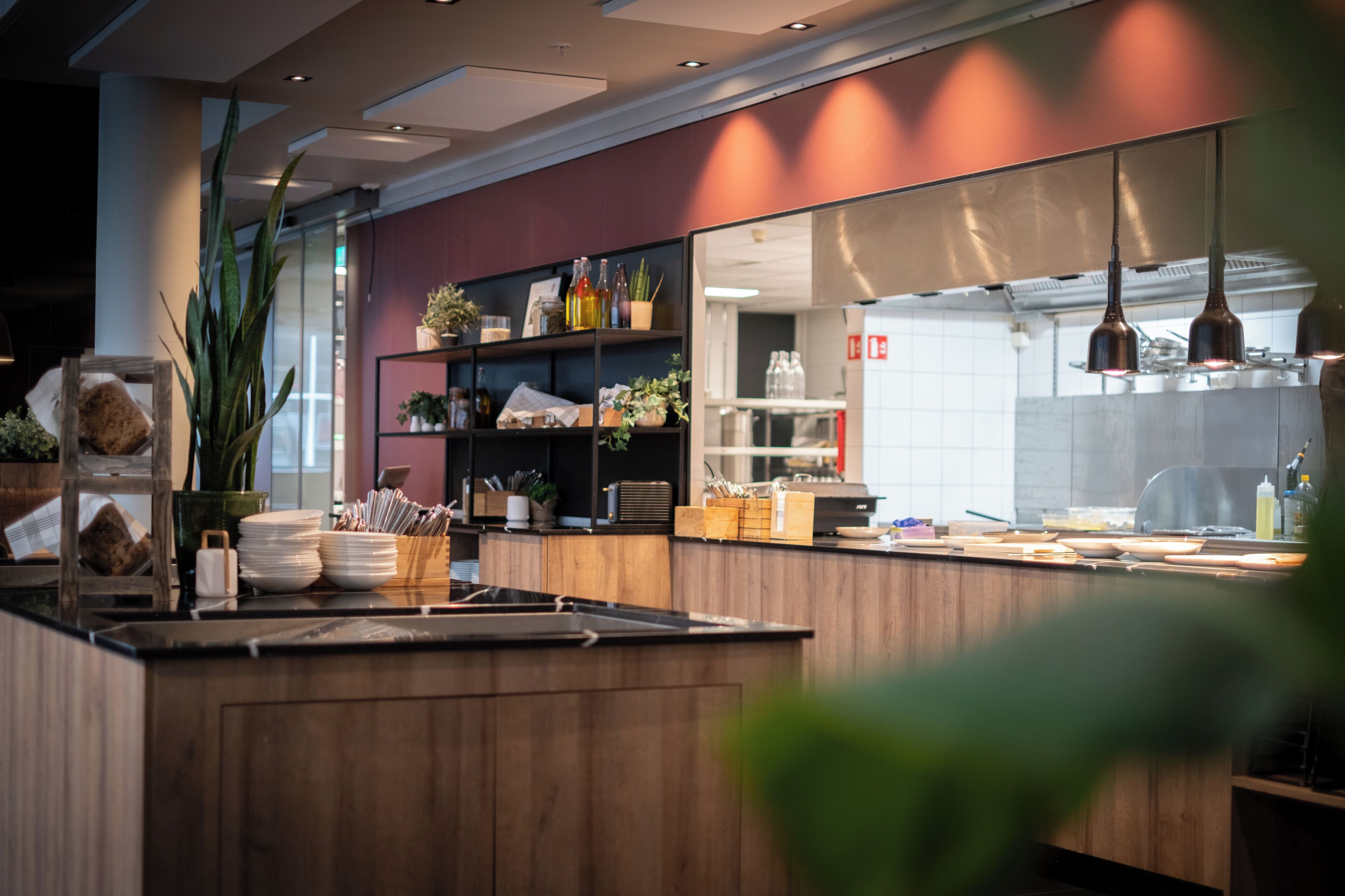 Een moderne keuken met houten kastjes, een groot eiland en diverse keukenapparaten.
