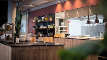 Een moderne keuken met houten kastjes, een groot eiland en diverse keukenapparaten.