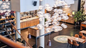 A modern hotel lobby with a central bar area, seating arrangements, and a staircase. - Quality Hotel Fredrikstad (Fredrikstad)
