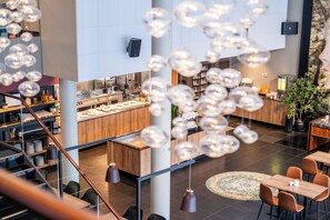 A modern hotel lobby with a central bar area, seating arrangements, and a staircase. - Quality Hotel Fredrikstad (Fredrikstad)