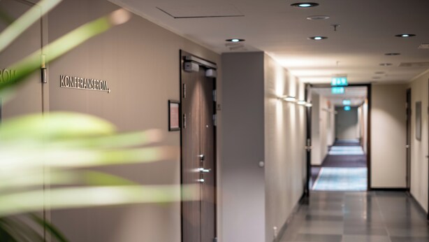 A hotel corridor with a sign reading "KONERANSEROM" on the wall, a door, and a blue carpeted floor. - Quality Hotel Fredrikstad (Fredrikstad)