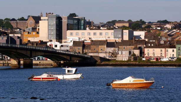 A bridge over a river with boats docked nearby.