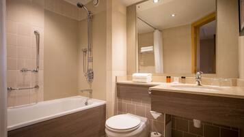 A modern bathroom with a bathtub, shower, toilet, and vanity.