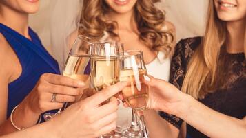 Eine Gruppe von Menschen sticht mit Champagnergläsern an.