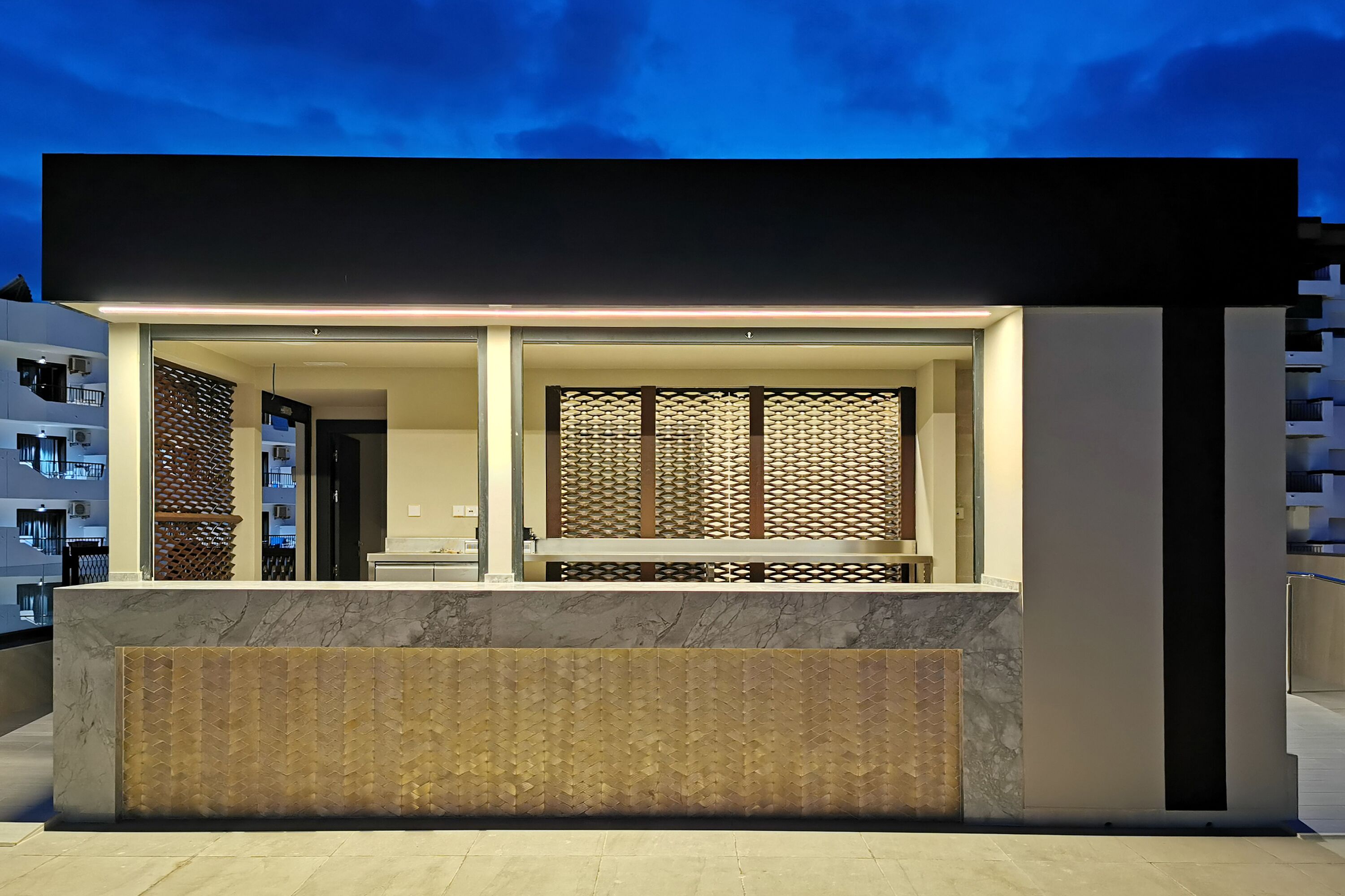 Un edificio moderno con área de recepción, ventanas amplias y una pared con diseño.