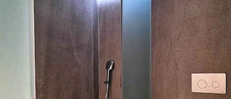 Bagno con doccia, WC e un fioriera a parete.