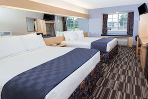 A hotel room with two beds, a desk, a mirror, a television, and a window with curtains. - Microtel Inn & Suites by Wyndham Conyers/Atlanta Area (Conyers)