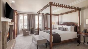 A four-poster bed, a fireplace, a television, and a balcony with curtains.