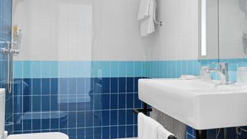 A modern bathroom with a shower, toilet, and sink.