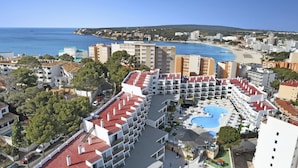 A resort with multiple buildings, a swimming pool, and a beach in the background. - Palmanova Suites by TRH (Calvia)