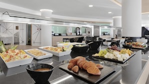A buffet with various food items and a modern kitchen in the background. - Palmanova Suites by TRH (Calvia)