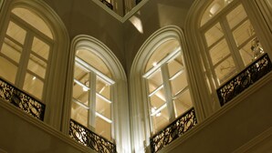 A high-ceilinged atrium with a skylight, arched windows, and ornate railings. - Villa Oniria (Granada)