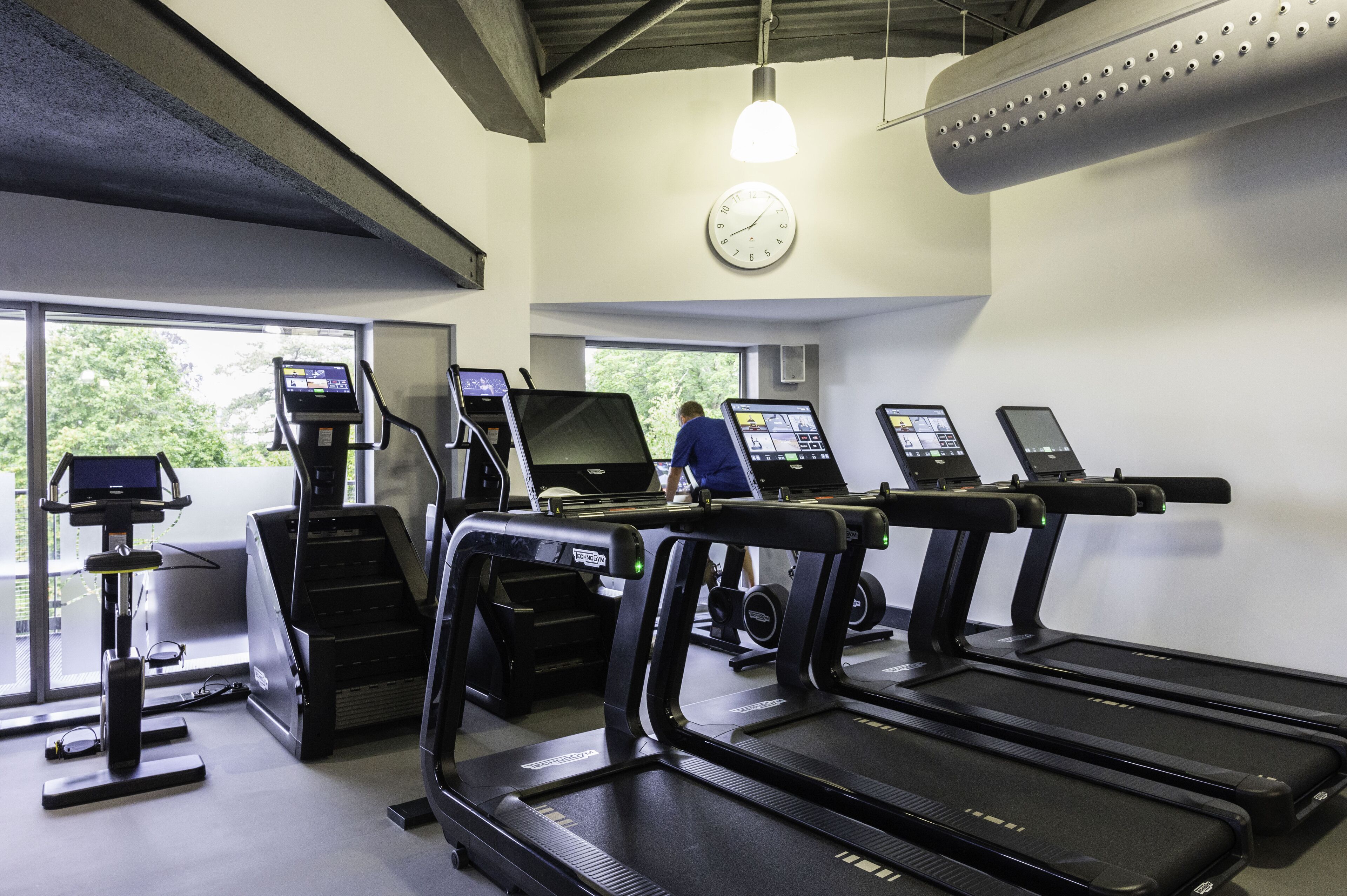 A gym with treadmills, a stair climber, and a weight machine.