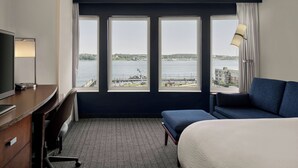 A hotel room with a large window, a bed, a desk, and a chair. - Courtyard by Marriott Halifax Downtown (Halifax)