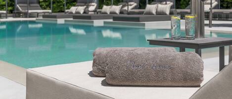 A poolside area with lounge chairs and a pool.