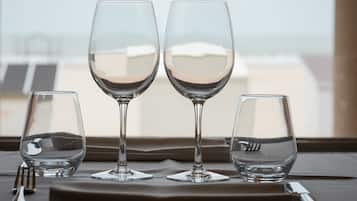 Tres copas de vino sobre una mesa, con vistas a edificios a través de una ventana.