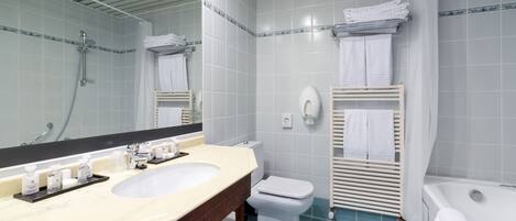 A bathroom with a double sink, toilet, and bathtub.