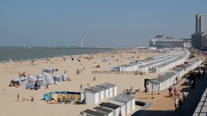 A beach with numerous beach huts and a promenade. - Thermae Palace Hotel (Ostend)