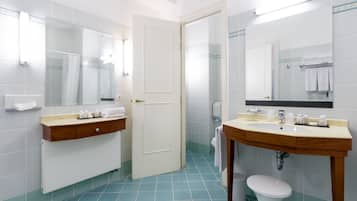 Een moderne badkamer met twee wastafels, toilet en douche.