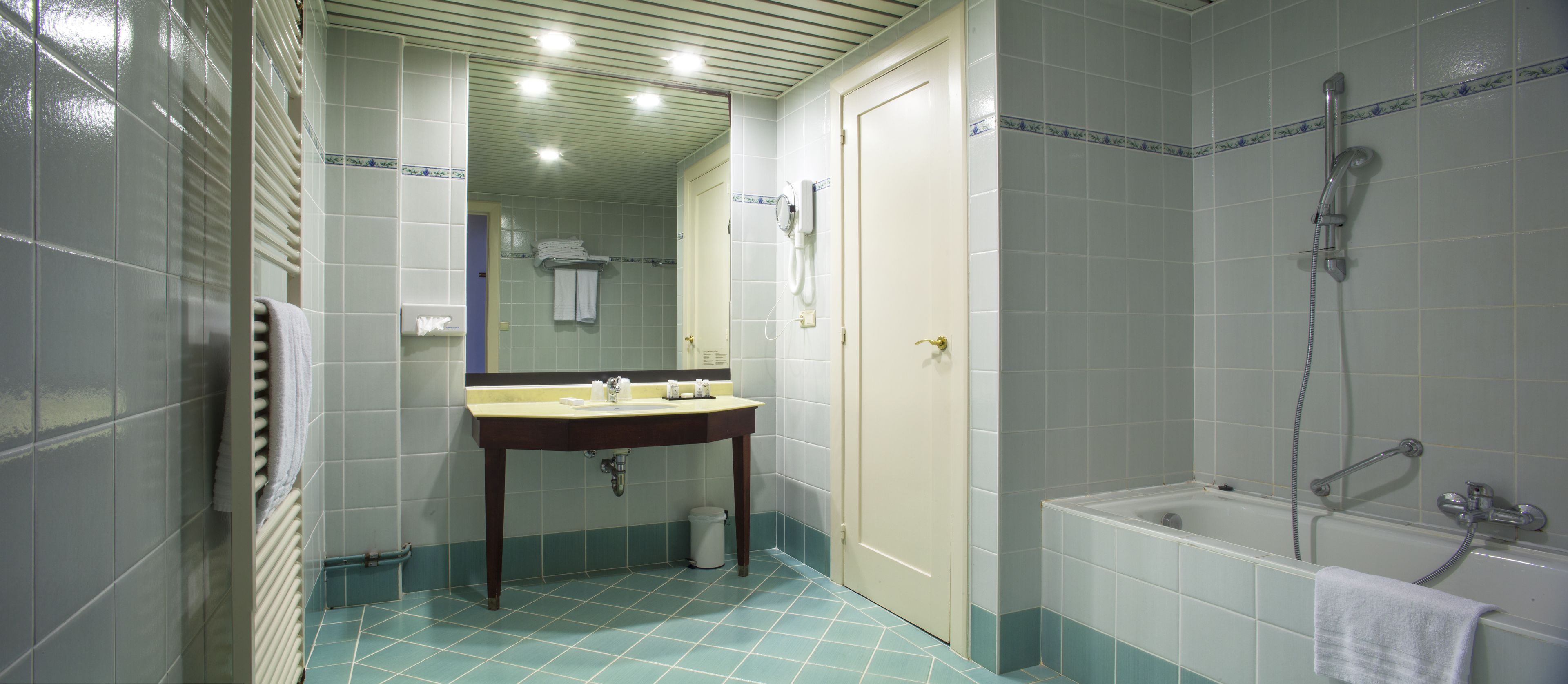 Un baño con lavamanos, espejo y ducha.