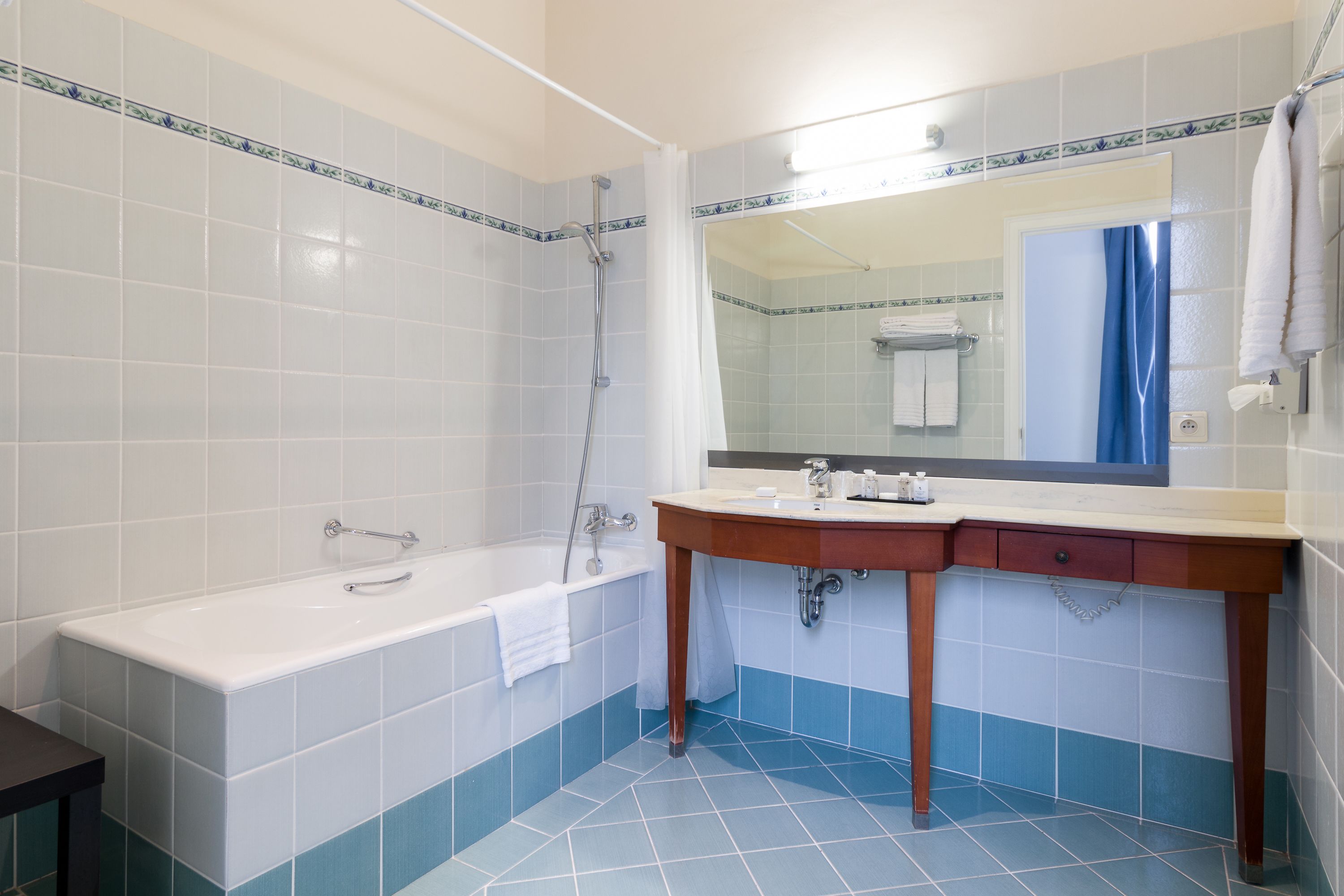 Ein Badezimmer mit Badewanne, Waschbecken und Spiegel.