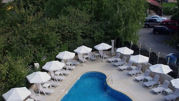 Una piscina al aire libre, sillones reclinables de piscina