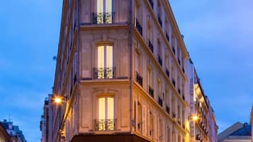 A multi-story hotel with a classic architectural design, featuring large windows and balconies.