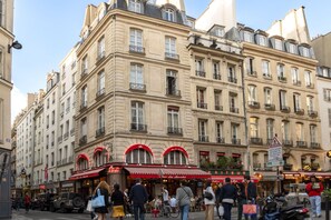 A historic building with multiple stories, featuring classic architectural details like arched windows and decorative balconies. - Hotel Delavigne (Paris)