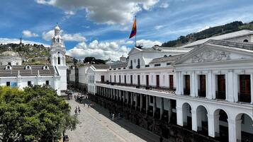 Un edificio histórico con un patio central, columnas y una bandera.