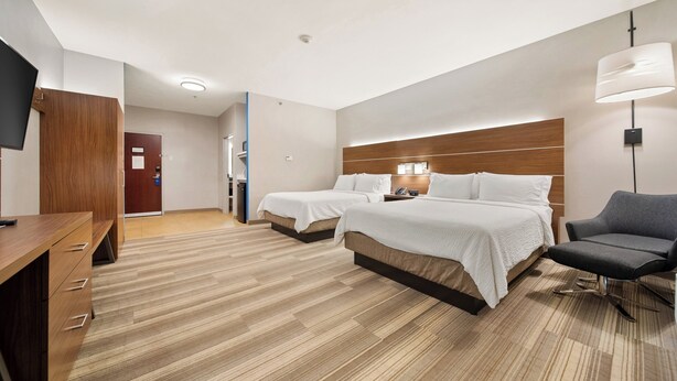 A hotel room with two beds, a desk, a chair, a TV, and a lamp. - Holiday Inn Express Hotel & Suites Trincity Trinidad Airport by IHG (Piarco)