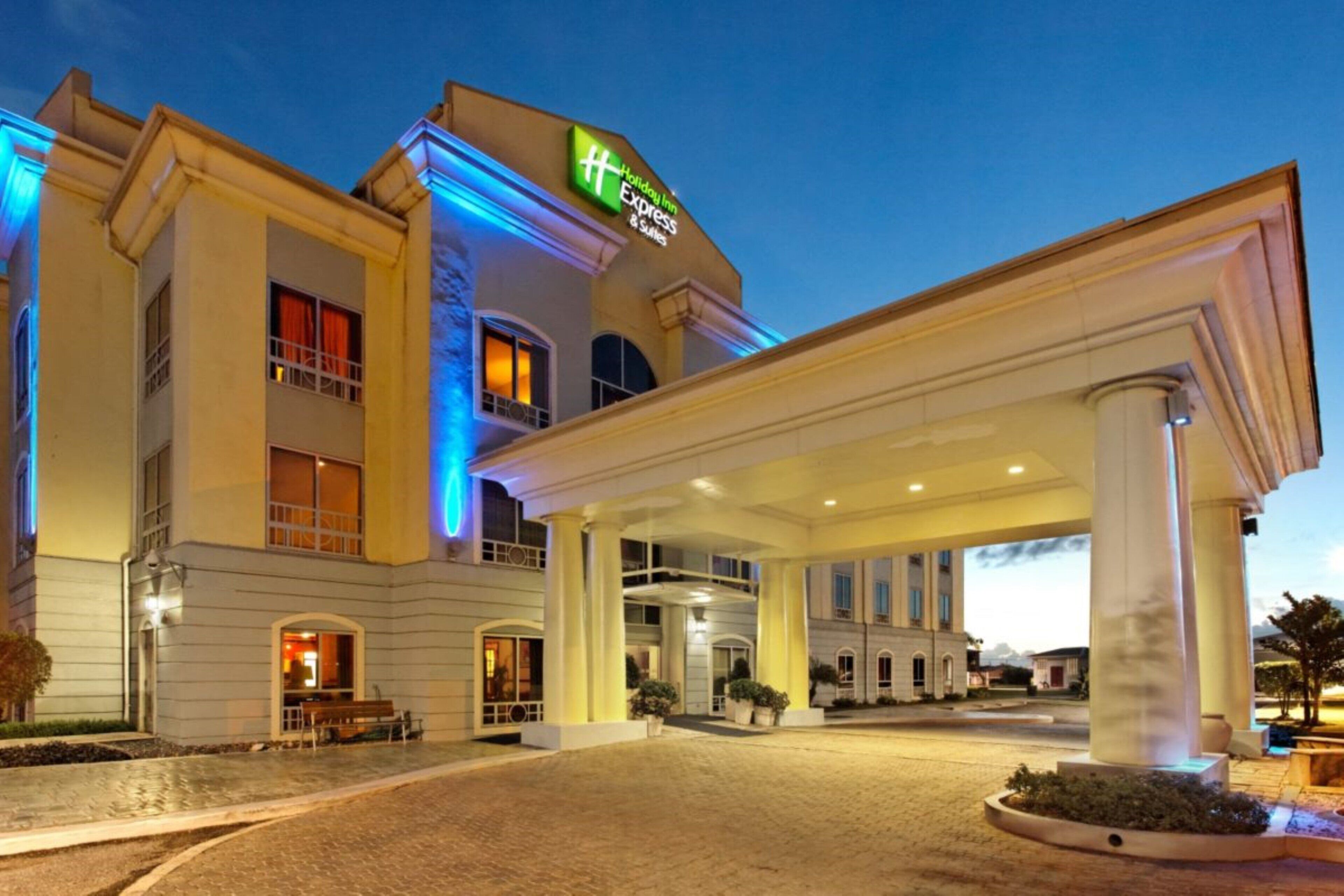 A hotel with a covered entrance, multiple windows, and a sign indicating it's a Holiday Inn Express.