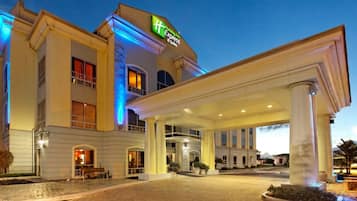 Un hotel con entrada cubierta, varias ventanas y un cartel que indica que es un Holiday Inn Express.