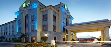 A Holiday Inn Express hotel with a large parking lot and a gas station.