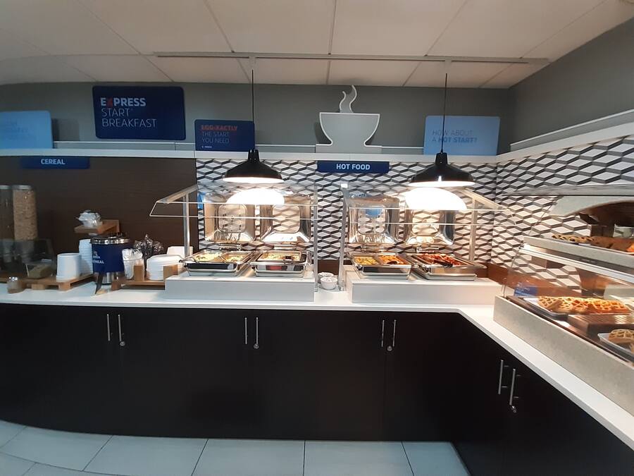 A breakfast buffet area with labeled sections for cereal, egg, and hot food.