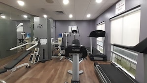 A gym with various exercise equipment, a treadmill, and a mirrored wall. - Holiday Inn Express Hotel & Suites Trincity Trinidad Airport by IHG (Piarco)
