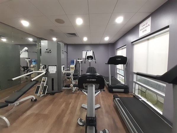 A gym with various exercise equipment, a treadmill, and a mirrored wall. - Holiday Inn Express Hotel & Suites Trincity Trinidad Airport by IHG (Piarco)