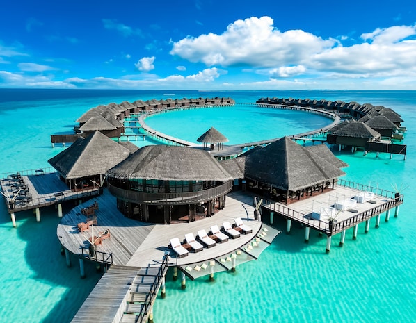An overwater resort with circular cabanas connected by walkways, offering ocean views. - Coco Bodu Hithi (Bodu Hithi)