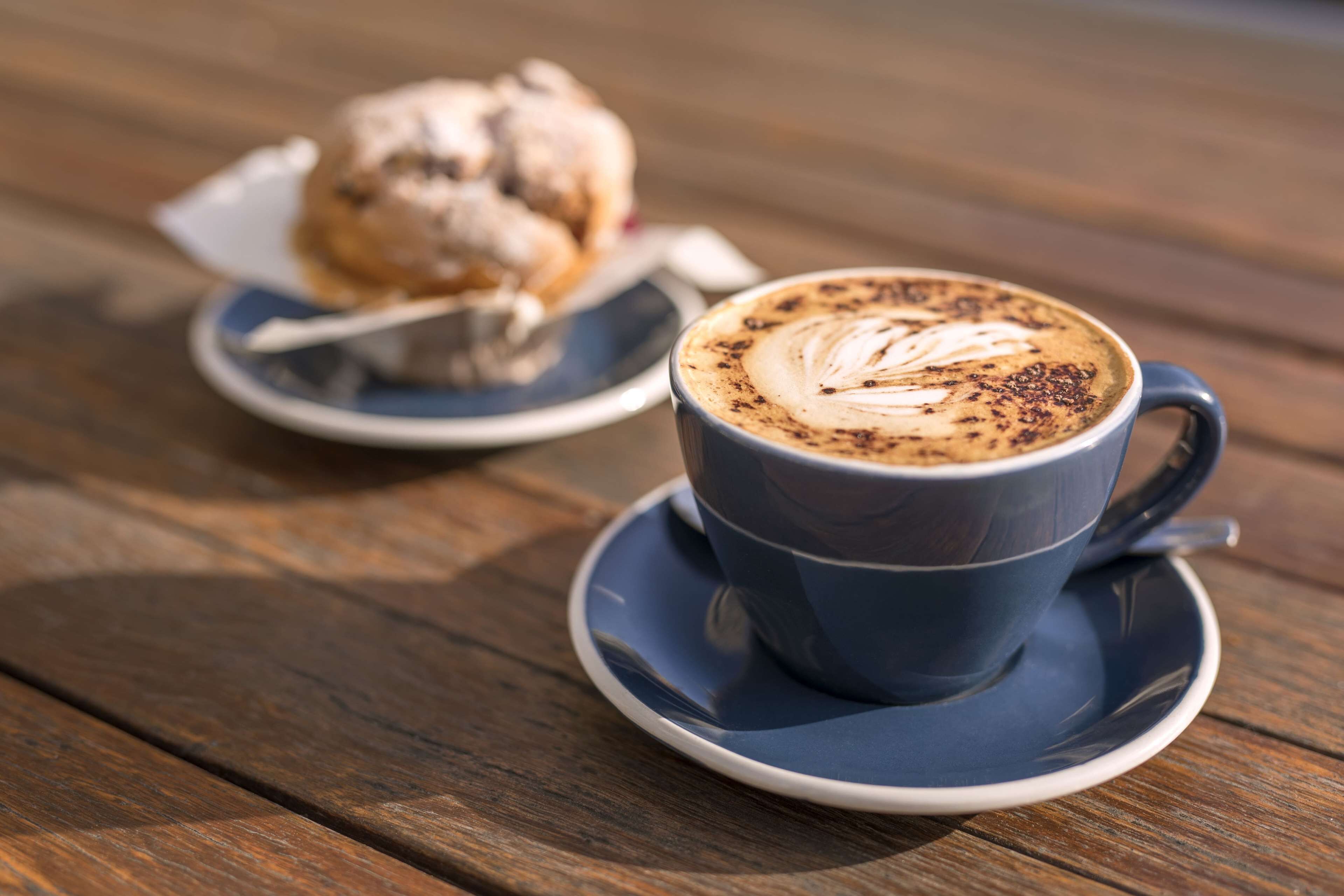 A cup of coffee with latte art on a wooden table.