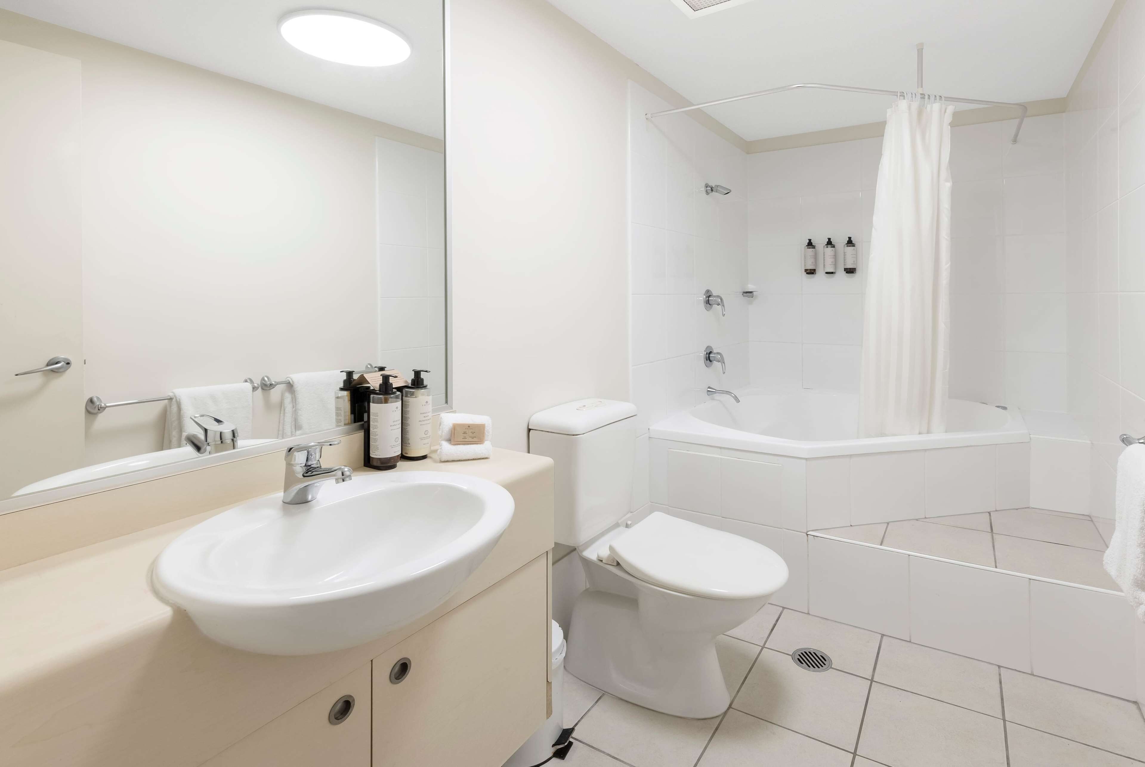 A modern bathroom with a sink, toilet, and bathtub.