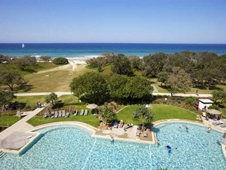 Een buitenzwembad, parasols voor strand/zwembad