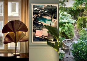 Et værelse med et stort vindue, et indrammet billede af en pool og en potteplante.
