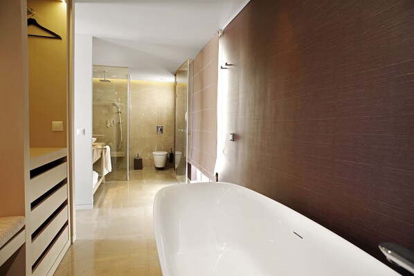 Une salle de bain moderne avec une grande baignoire, une cabine de douche en verre et un mur en bois.