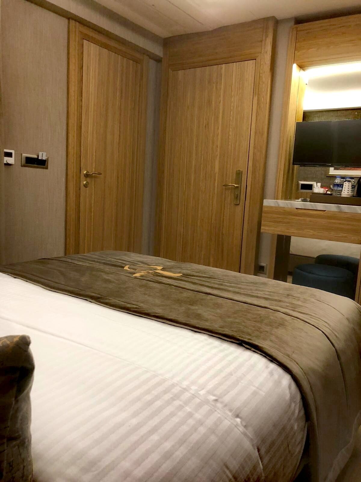Ein Hotelzimmer mit Bett, Holzschrank und einer kleinen Küchenzeile.