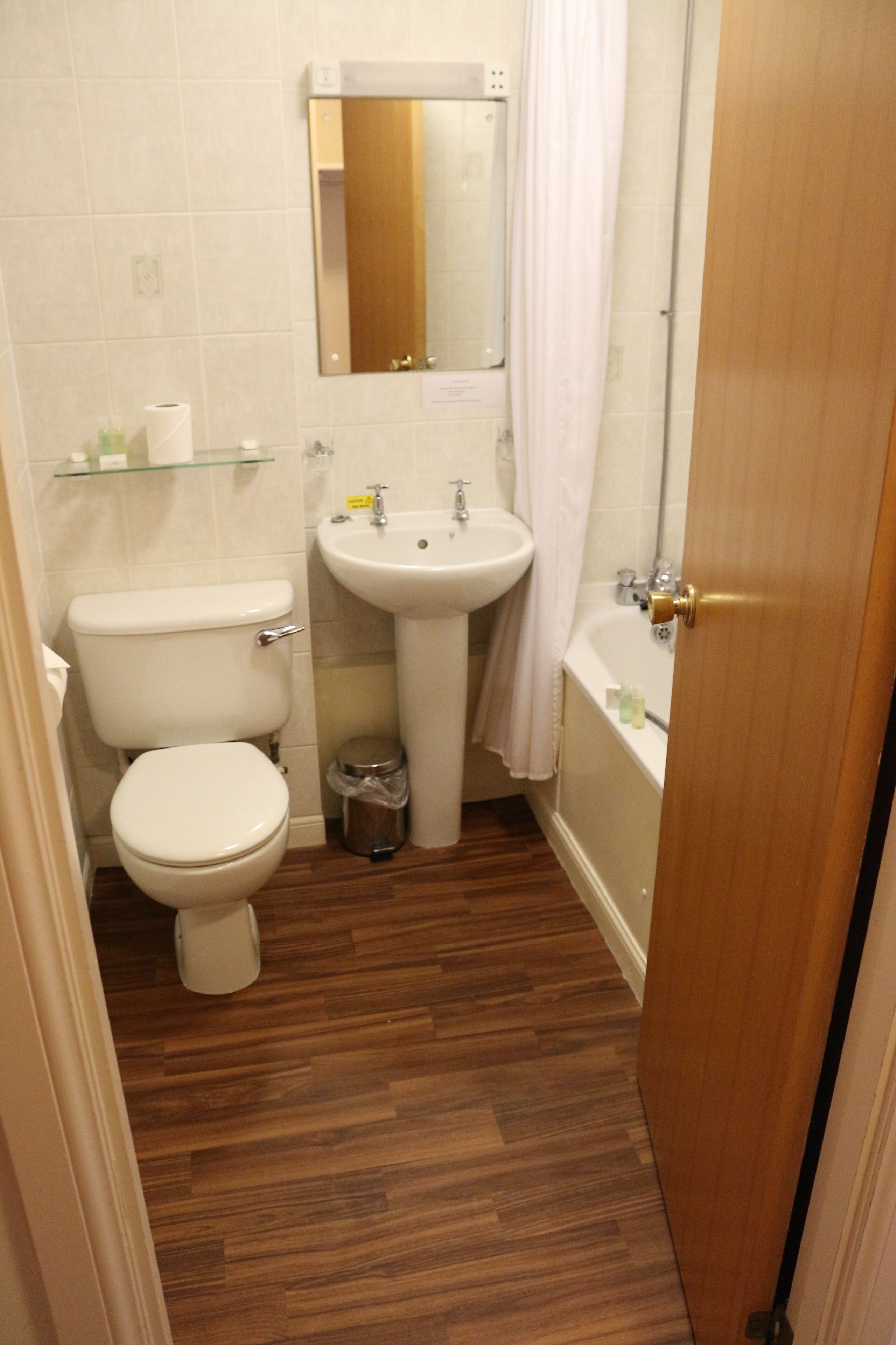 A compact bathroom with a toilet, sink, and bathtub.