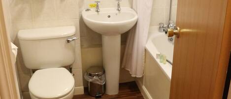 A compact bathroom with a toilet, sink, and bathtub.