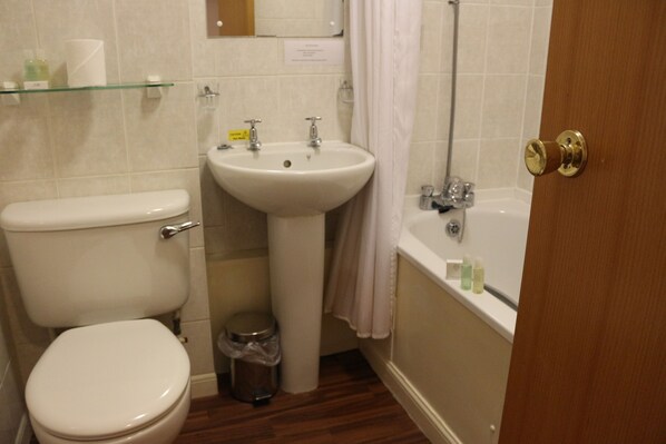 A bathroom with a toilet, sink, and bathtub.