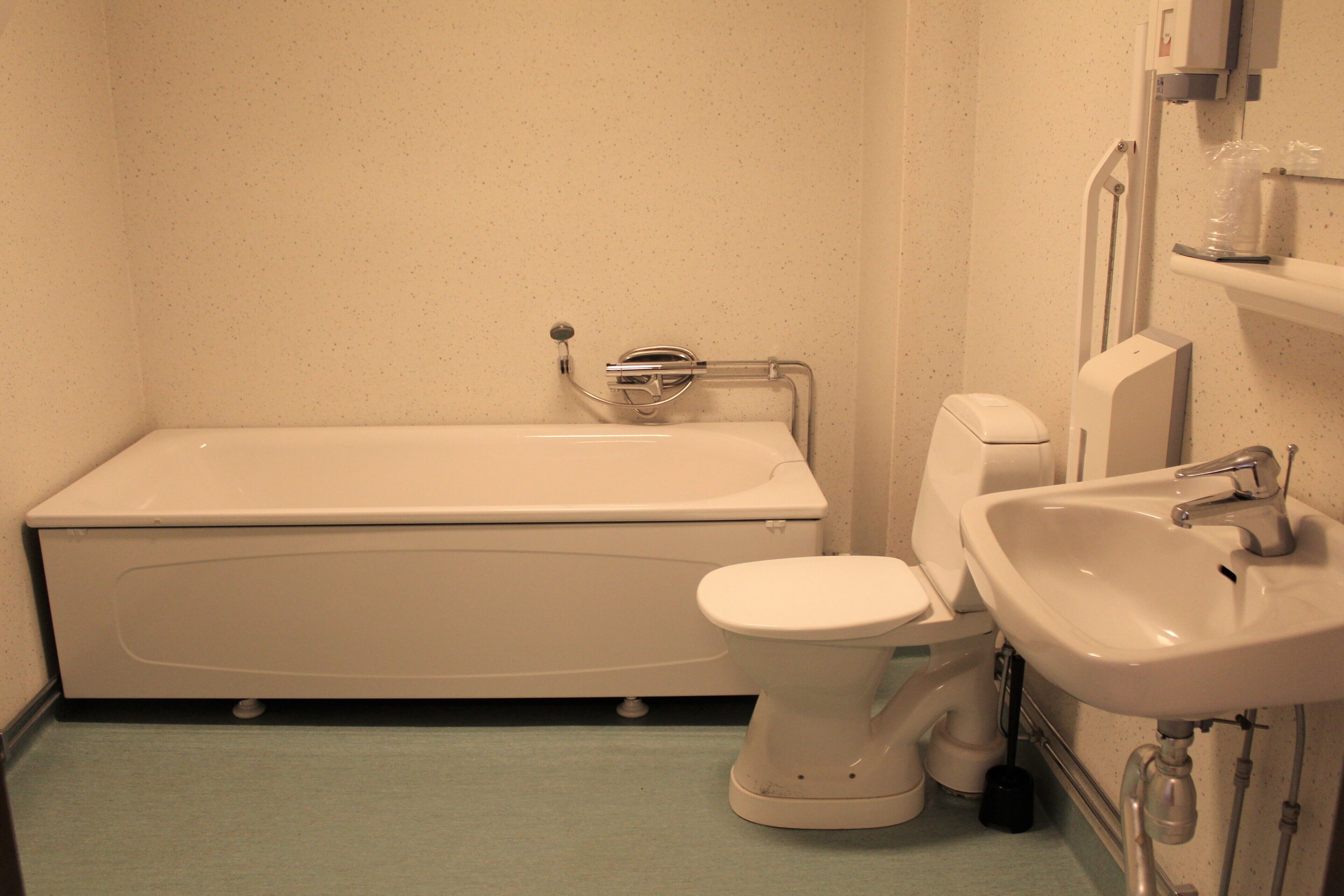 A bathroom with a bathtub, toilet, and sink.