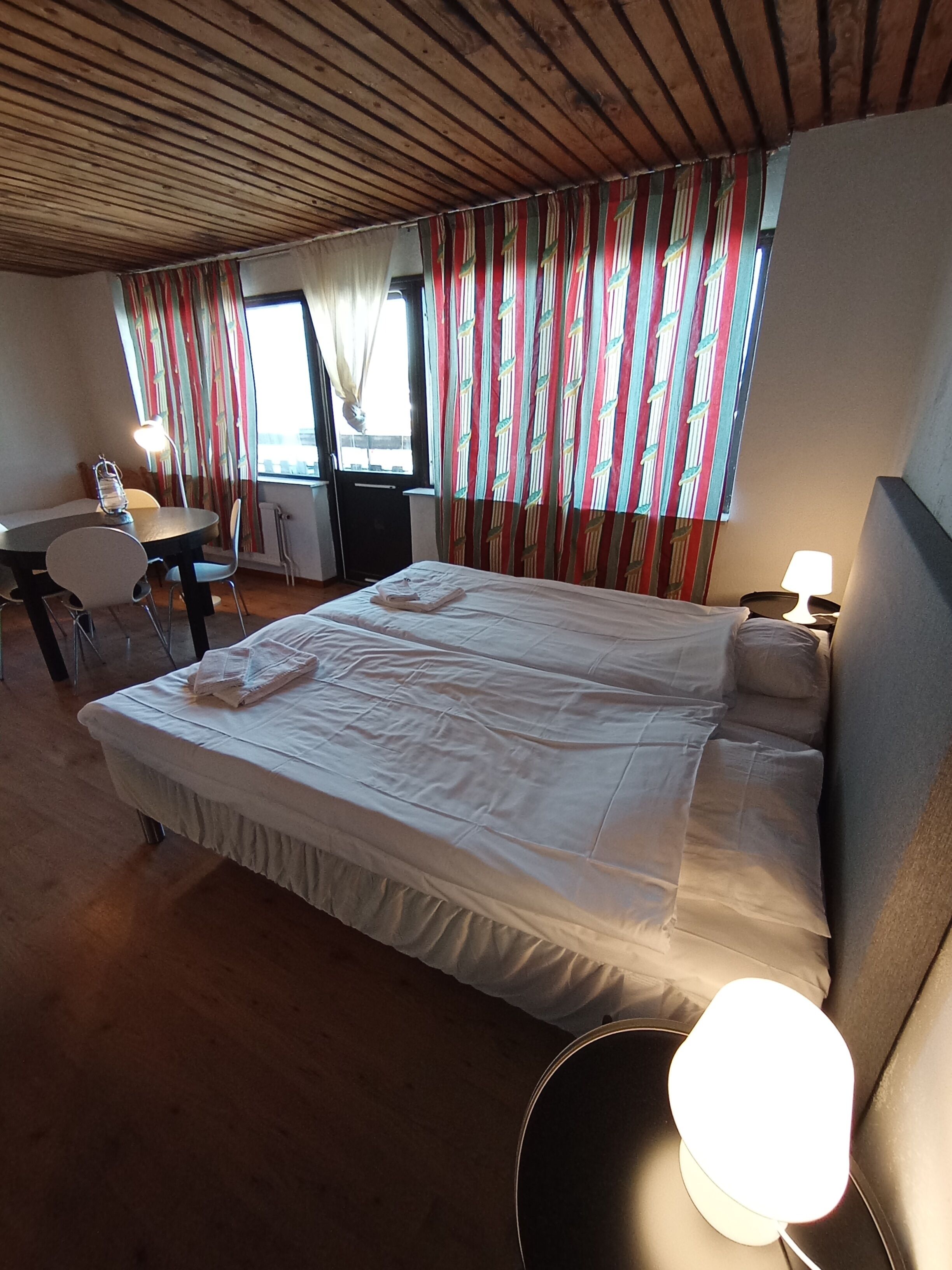 Ett hotellrum med en stor säng, ett skrivbord och en stol.