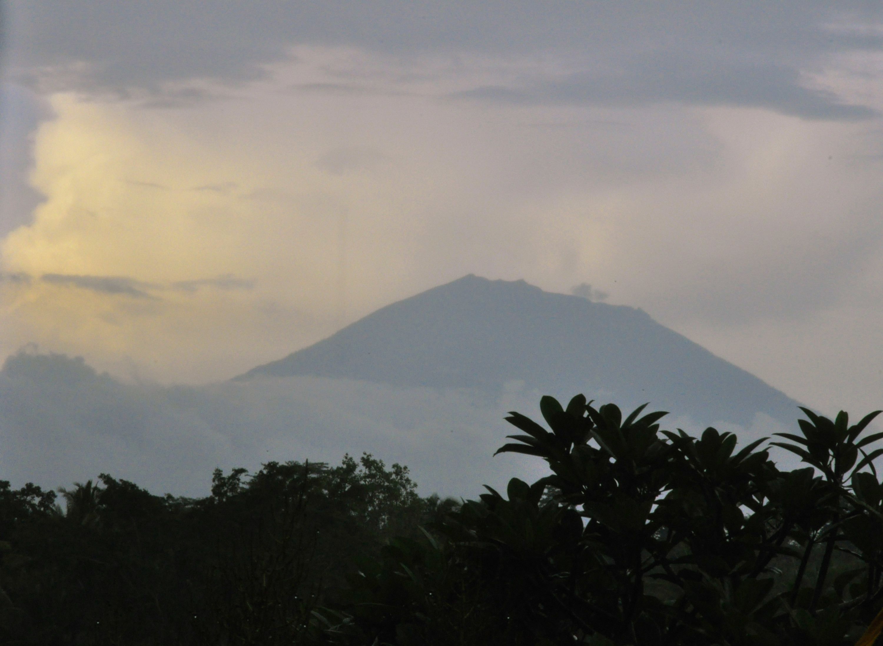 A mountain with a cloudy sky.