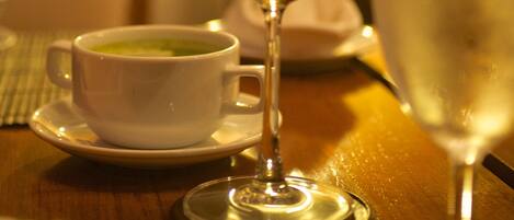 A table with a wine glass, a cup of tea, and a glass of water.